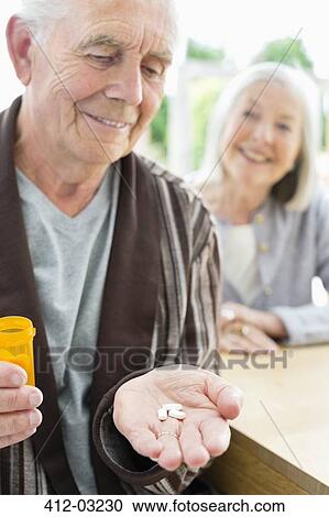 Older man with handful of pills View Large Photo Image Stock Image - Older man with handful of pills. Fotosearch