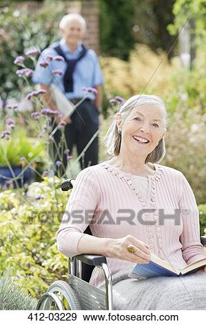 Older woman in wheelchair reading outdoors View Large Photo Image Stock Photo - Older woman in wheelchair reading outdoors. Fotosearch