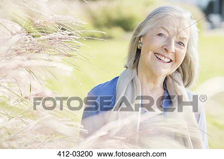 Older woman smiling outdoors View Large Photo Image Stock Image - Older woman smiling outdoors. Fotosearch