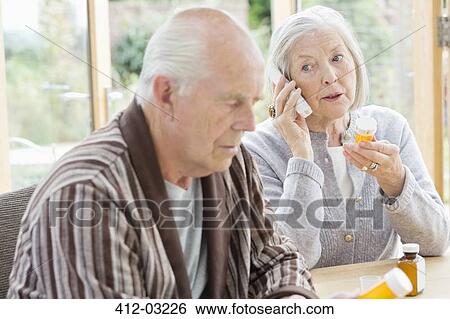 Stock Photograph - Older woman with medications talking on phone. Fotosearch