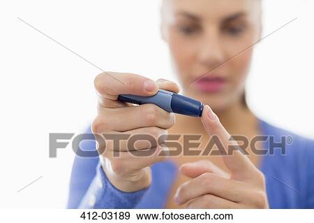 Woman taking her own blood sugar View Large Photo Image Stock Photo - Woman taking her own blood sugar. Fotosearch