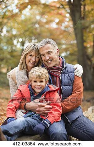 Picture - Boy smiling with grandparents in park. Fotosearch
