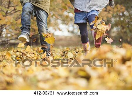 Children walking in autumn leaves View Large Photo Image Stock Image - Children walking in autumn leaves. Fotosearch
