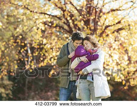 Couple cradling baby in park View Large Photo Image Stock Photo - Couple cradling baby in park. Fotosearch