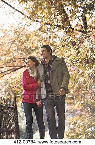 Picture - Couple walking together in park. Fotosearch