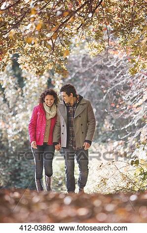 Couple walking together in park View Large Photo Image Stock Image - Couple walking together in park. Fotosearch