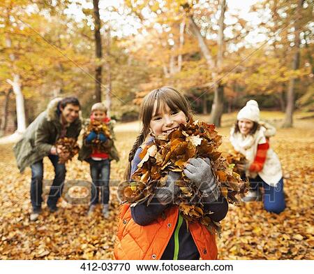 Family playing in autumn leaves View Large Photo Image Stock Image - Family playing in autumn leaves. Fotosearch