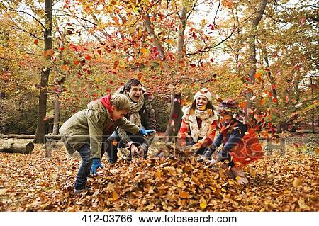 Family playing in autumn leaves View Large Photo Image Stock Photograph - Family playing in autumn leaves. Fotosearch