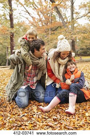 Family playing together in autumn leaves View Large Photo Image Stock Image - Family playing together in autumn leaves. Fotosearch