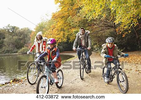 Family riding bicycles in park View Large Photo Image Stock Image - Family riding bicycles in park. Fotosearch