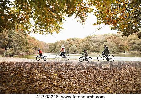 Stock Photograph - Family riding bicycles in park. Fotosearch