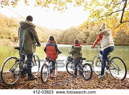 Family sitting on bicycles together in park View Large Photo Image Stock Image - Family sitting on bicycles together in park. Fotosearch