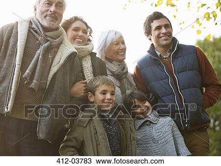 Stock Image - Family smiling together in park. Fotosearch