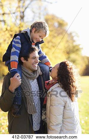 Stock Photo - Family smiling together in park. Fotosearch