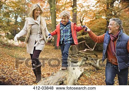Stock Photo - Family walking on log in park. Fotosearch