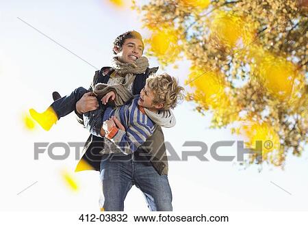 Stock Image - Father and son playing in park. Fotosearch
