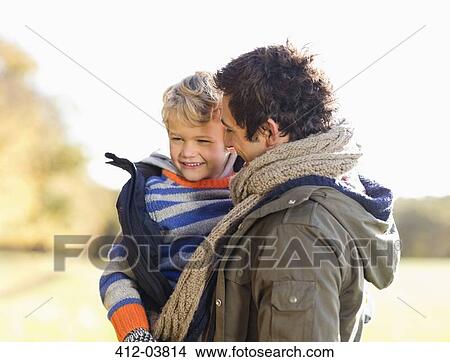 Picture - Father carrying son outdoors. Fotosearch