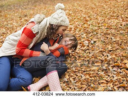 Mother and daughter playing in autumn leaves View Large Photo Image Picture - Mother and daughter playing in autumn leaves. Fotosearch