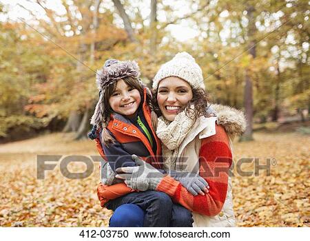 Mother and daughter smiling in autumn leaves View Large Photo Image Stock Image - Mother and daughter smiling in autumn leaves. Fotosearch