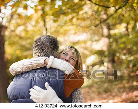 Picture - Older couple hugging in park. Fotosearch