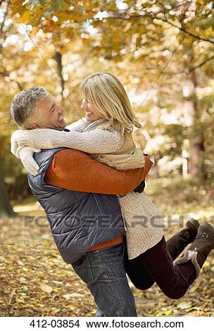 Picture - Older couple hugging in park. Fotosearch