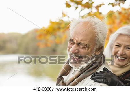 Stock Photo - Older couple laughing together in park. Fotosearch