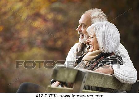 Older couple sitting on park bench View Large Photo Image Stock Image - Older couple sitting on park bench. Fotosearch