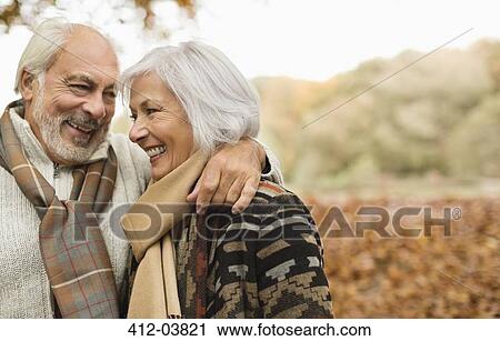 Stock Image - Older couple smiling together in park. Fotosearch