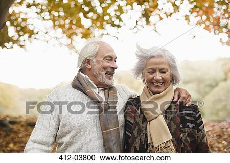 Stock Image - Older couple walking together in park. Fotosearch