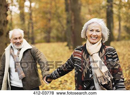 Stock Photo - Older couple walking together in park. Fotosearch
