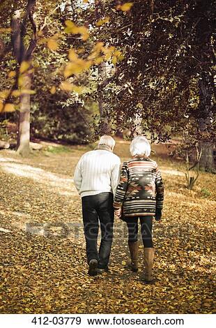Older couple walking together in park View Large Photo Image Stock Photo - Older couple walking together in park. Fotosearch