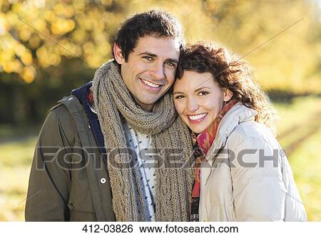 Smiling couple hugging in park View Large Photo Image Stock Photograph - Smiling couple hugging in park. Fotosearch