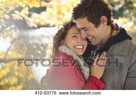 Stock Photography - Smiling couple hugging in park. Fotosearch