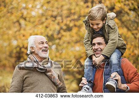 Stock Image - Three generations of men smiling in park. Fotosearch