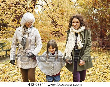 Picture - Three generations of women walking in park. Fotosearch