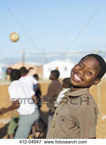 Boy smiling in dirt field View Large Photo Image Stock Photo - Boy smiling in dirt field. Fotosearch