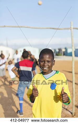 Boy smiling in dirt field View Large Photo Image Stock Photo - Boy smiling in dirt field. Fotosearch