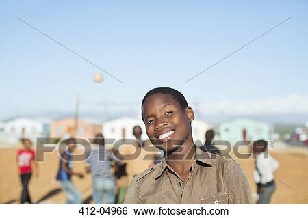 Stock Photograph - Boy smiling in dirt field. Fotosearch