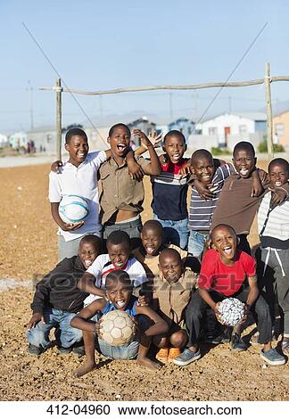 Boys holding soccer balls in dirt field View Large Photo Image Stock Image - Boys holding soccer balls in dirt field. Fotosearch