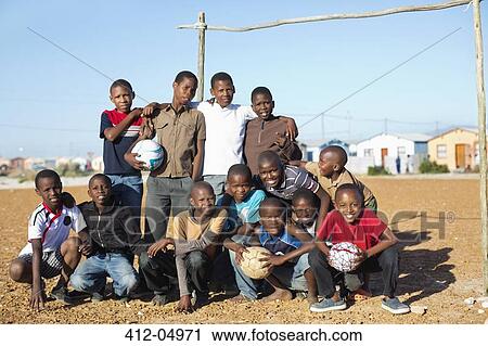 Boys holding soccer balls in dirt field View Large Photo Image Stock Image - Boys holding soccer balls in dirt field. Fotosearch