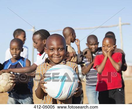 Boys holding soccer balls in dirt field View Large Photo Image Stock Photography - Boys holding soccer balls in dirt field. Fotosearch