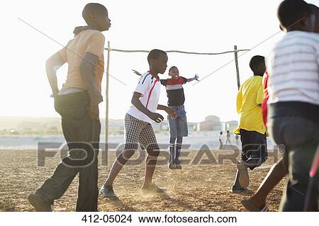Boys playing soccer together in dirt field View Large Photo Image Picture - Boys playing soccer together in dirt field. Fotosearch