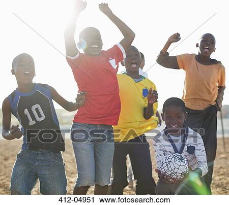Boys playing soccer together in dirt field View Large Photo Image Stock Image - Boys playing soccer together in dirt field. Fotosearch