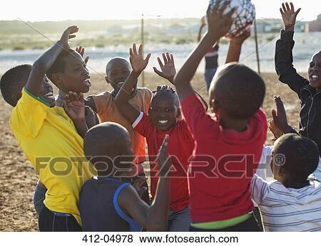 Boys playing soccer together in dirt field View Large Photo Image Stock Photo - Boys playing soccer together in dirt field. Fotosearch