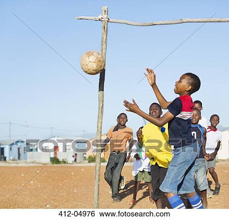 Boys playing soccer together in dirt field View Large Photo Image Stock Photograph - Boys playing soccer together in dirt field. Fotosearch