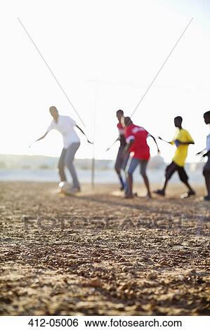 Boys playing soccer together in dirt field View Large Photo Image Stock Photograph - Boys playing soccer together in dirt field. Fotosearch