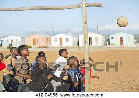 Boys playing soccer together in dirt field View Large Photo Image Stock Photography - Boys playing soccer together in dirt field. Fotosearch