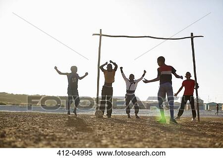 Boys playing soccer together in dirt field View Large Photo Image Stock Photography - Boys playing soccer together in dirt field. Fotosearch