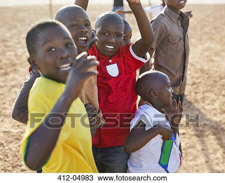 Boys playing together in dirt field View Large Photo Image Stock Image - Boys playing together in dirt field. Fotosearch