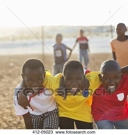 Boys playing together in dirt field View Large Photo Image Stock Image - Boys playing together in dirt field. Fotosearch